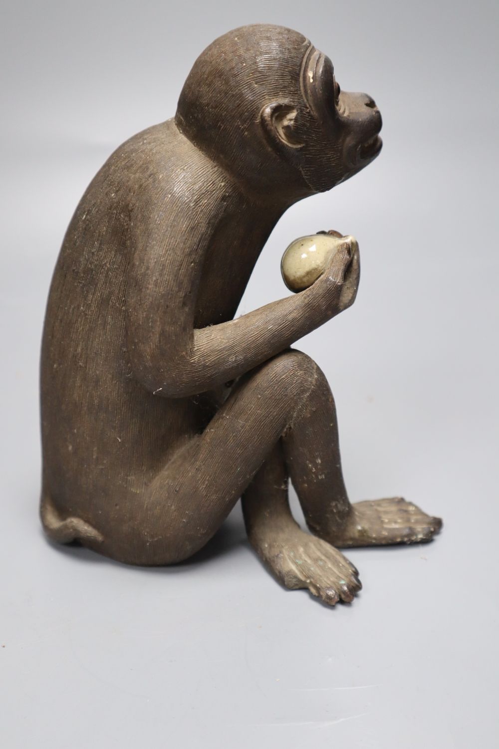 A Japanese stoneware figure of a monkey holding a peach, height 17cm